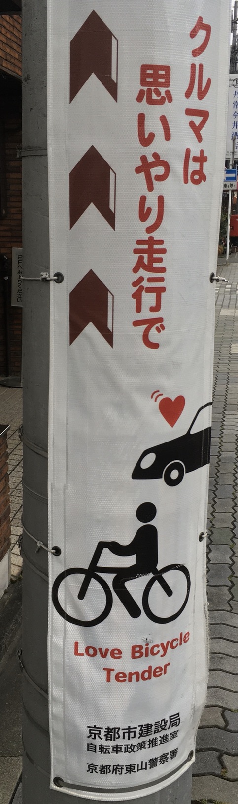 日本語は「クルマは思いやり走行で」、英語は「Love Bicycle Tender」。